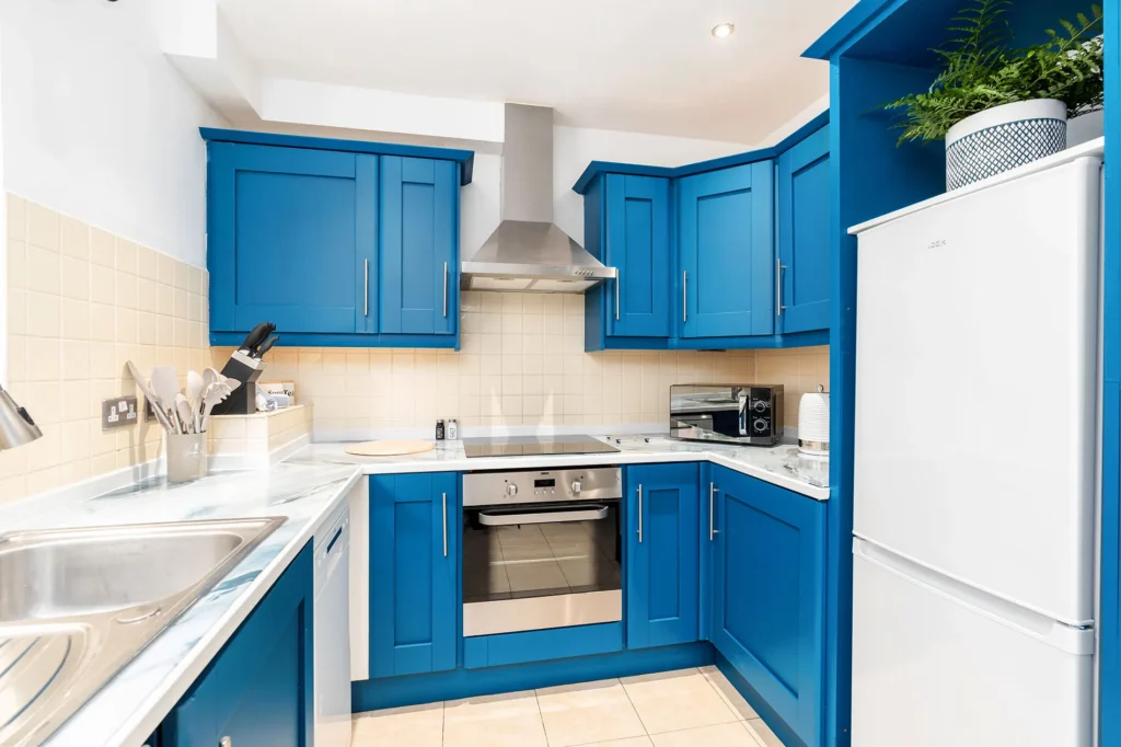 a kitchen with blue cabinets and white appliances